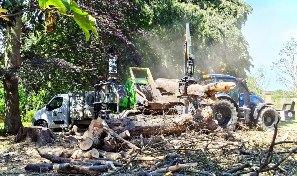 A heizohack being fed locks to chip by a tractor with a crane arm attachement. Winner of the Media of the Month at STS.
